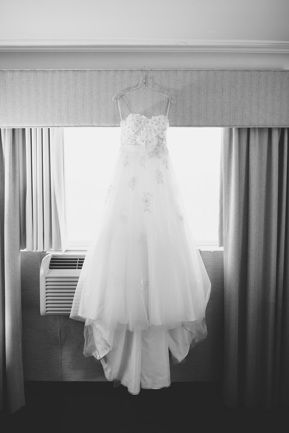 Wedding dress hanging on hangar in hotel room