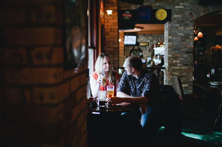 Toronto Engagement Photographer: couple drinking beer in pub